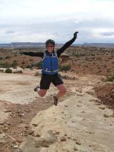 Michelle jumps for joy at the dinosaur tracks, Klondike Bluffs